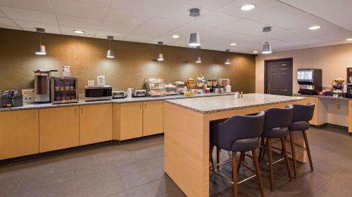 a kitchen with a counter and bar stools at Best Western On The Avenue in Buffalo