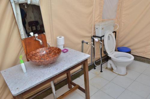 a bathroom with a sink and a toilet in a tent at Cola Beach Sunset Bay in Cola