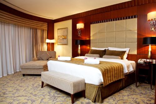 a hotel room with a large bed and a chair at Concorde Hotel Fujairah in Fujairah