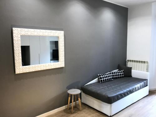 a bedroom with a bed with a mirror and a stool at P&D Apartments Navigli in Milan
