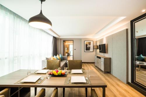 a dining room and living room with a dining table at Citrus Suites Sukhumvit 6 by Compass Hospitality in Bangkok