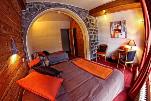- une chambre avec un lit dans une pièce dotée d'un mur en pierre dans l'établissement La Maison Rapin, à Valloire