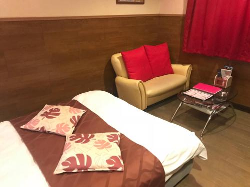 a bedroom with a chair and a bed and a chair at Hotel Vegas (Adult Only) in Sapporo