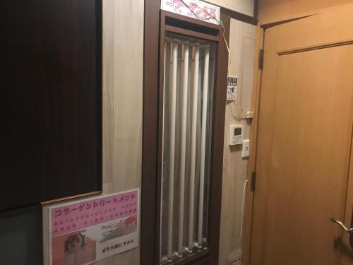 a bathroom with a door with a window and a sign at Hotel Vegas (Adult Only) in Sapporo
