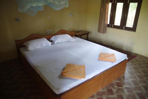 a bedroom with a large bed with two towels on it at Jungle Base Camp in Bardia