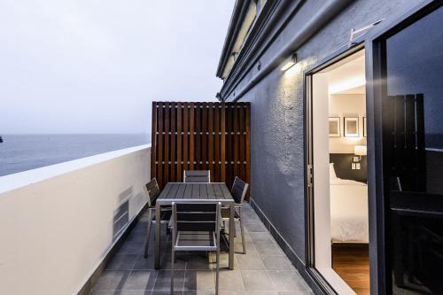 a table and chairs on a balcony with the ocean at Hotel Hyggelig in Busan