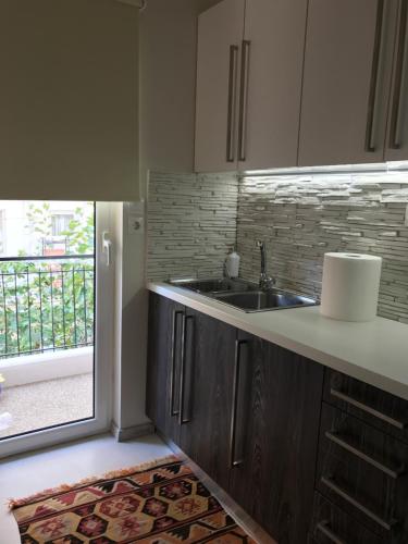 uma cozinha com um lavatório e uma janela em Apartment near the Beach em Atenas