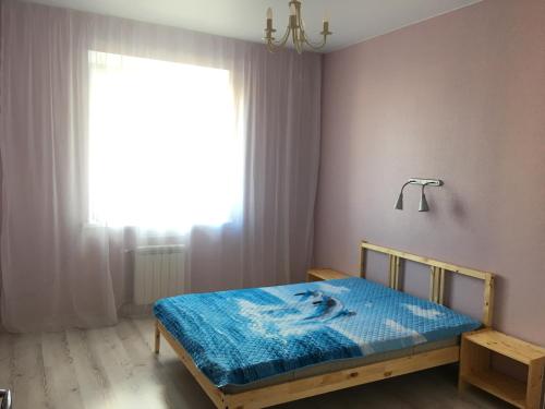 オムスクにあるApartment Berloga55 on Krasnyi Put'のベッドルーム1室(青い毛布付きのベッド1台付)