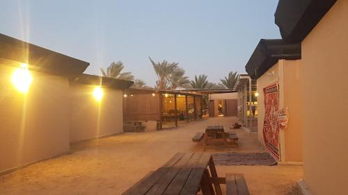 a courtyard of a building with benches and palm trees at Ras Hasita in H̱aẕeva
