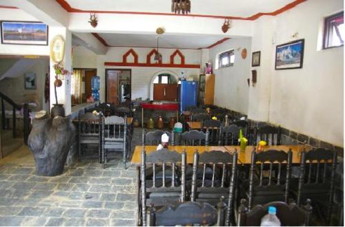 a restaurant with tables and chairs in a room at Shrestha Hotel & Restaurant in Bandipur