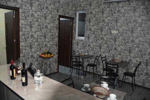 a dining room with tables and chairs and a brick wall at City Hotel in Tbilisi City