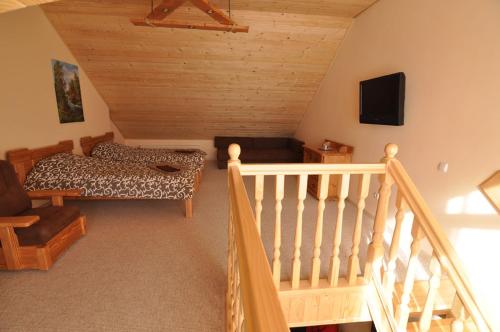 a room with a staircase with a bed and a tv at Dayarta in Skhidnitsa