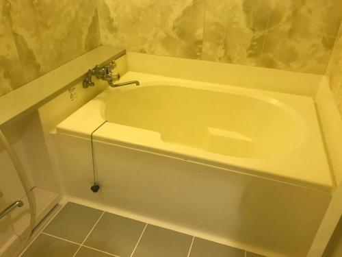 a white bath tub with a faucet in a bathroom at Hotel Vegas (Adult Only) in Sapporo