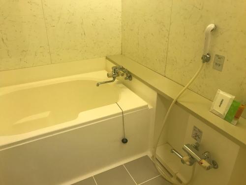 a bathroom with a bathtub with a hose attached at Hotel Vegas (Adult Only) in Sapporo