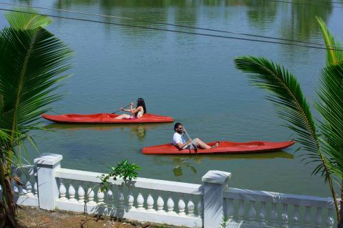 two women are sitting on kayaks in the water at Indriya Sands in Cherai Beach