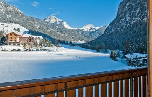a view from a balcony of a snow covered mountain at Cesa Edelweiss Living & Spa in Campitello di Fassa