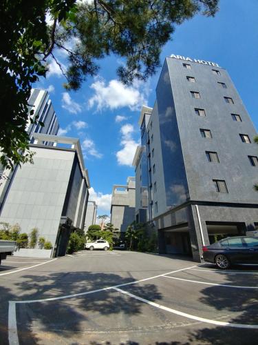 a car parked in a parking lot in front of two buildings at Seosan Aria Hotel in Seosan