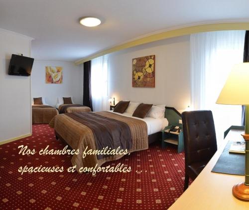 um quarto de hotel com uma cama grande e um sofá em The Originals City, Hôtel du Faucigny, Cluses Ouest em Scionzier