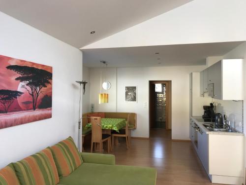a kitchen and a living room with a couch and a table at Ferienwohnung Schweiberer in Fügen