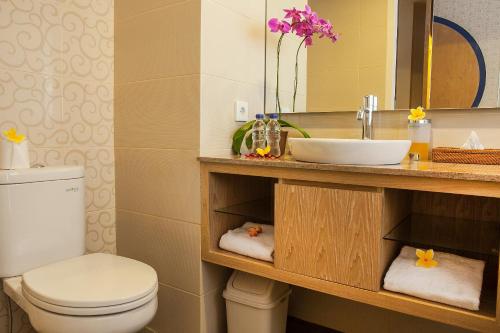 クタにあるナチャ ホテル クタのバスルーム(洗面台、トイレ、鏡付)