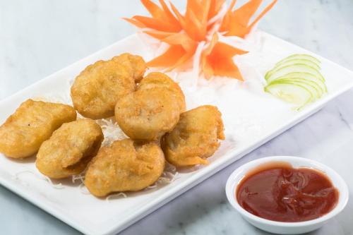 a plate of food with wontons and a bowl of ketchup at P Plus Hotel in Pattaya Central