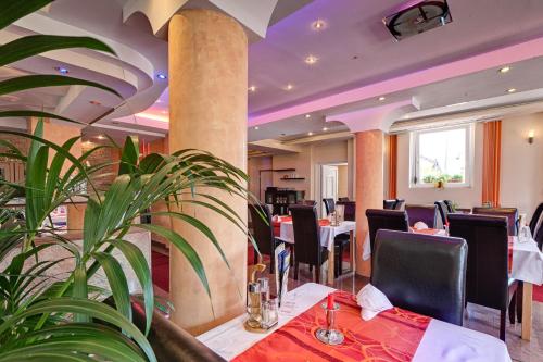 un restaurante con mesas, sillas y una planta en Hotel zum Ochsen, en Bietigheim