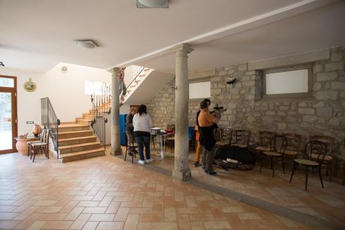 people standing in a room with a stone wall at Agriturismo I Fondacci in Grizzana