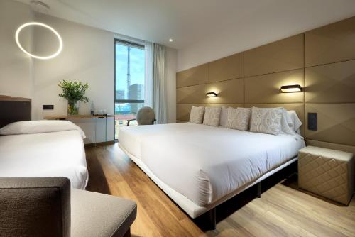 a bedroom with a large white bed and a chair at Hotel SB Glow 4 Sup in Barcelona