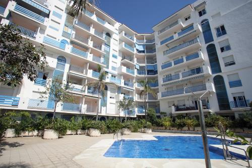 un edificio de apartamentos con piscina frente a él en Apartamento El Faro Leisure Port, en Estepona