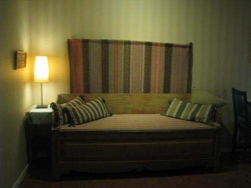 a bed in a room with a lamp next to it at Örnsköldsviks Vandrarhem in Örnsköldsvik
