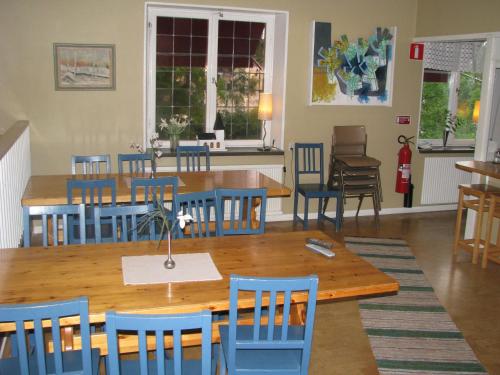 a dining room with a wooden table and blue chairs at Örnsköldsviks Vandrarhem in Örnsköldsvik
