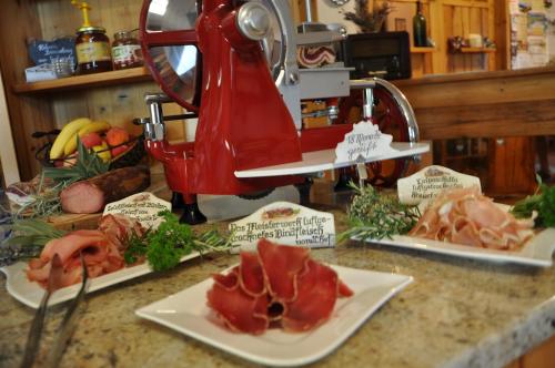 a kitchen counter with plates of meat and a juicer at Gmiatliche Stubm in Loipersdorf bei Fürstenfeld