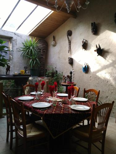 une table à manger avec des chaises et une table avec des assiettes dans l'établissement Chambre d'hôtes Le Moulin de Moulis, à Moulis-en-Médoc