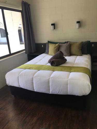 a large bed sitting in a room with a window at Azalea Motel in Coonabarabran