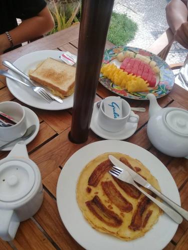 ein Holztisch mit Tellern voller Essen darauf in der Unterkunft Rumah Saga in Gili Trawangan