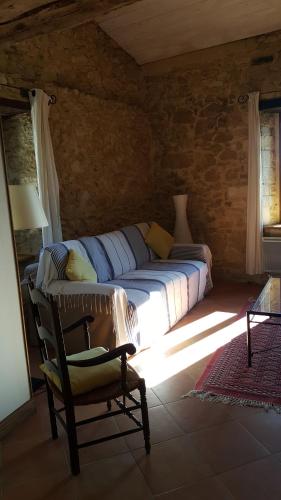 ein Schlafzimmer mit einem Bett und einem Stuhl in einem Zimmer in der Unterkunft Gîte Picanas in Boussan