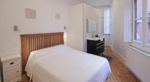 a bedroom with a white bed and a dresser and a window at T4 du Languedoc in Toulouse
