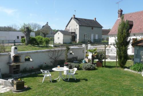 a garden with a table and chairs in the yard at Aux Jardin's de la Bosniere in Cussay