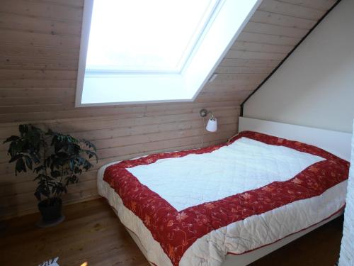 a bedroom with a bed with a red and white quilt at Privatzimmer Frank in Tarp