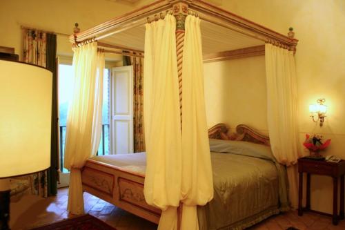 a bedroom with a canopy bed with white curtains at Tenuta Del Gallo in Amelia