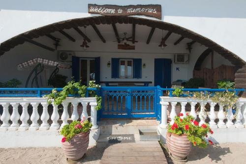 a house with a blue and white fence and potted plants at Sweet Memories Beach Houses in Mesongi