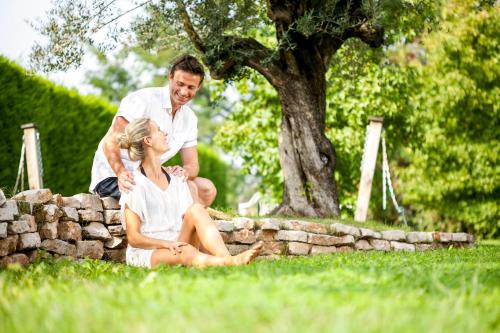 a man and a woman sitting on a stone wall at Atlantic Terme Natural Spa & Hotel in Abano Terme