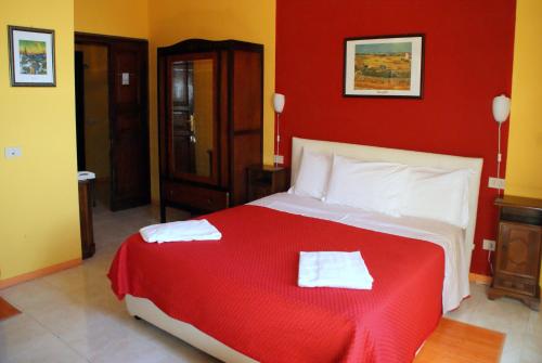 a red bedroom with a bed with two towels on it at Hotel Europa in Perugia