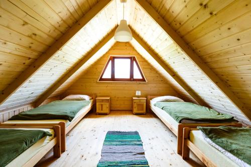 twee bedden in een kleine kamer in een blokhut bij Domki u Bronki in Grywałd