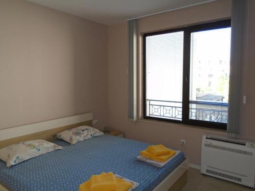 een kleine slaapkamer met een bed en een raam bij Nedev's Apartments in Kavatsi Area in Sozopol