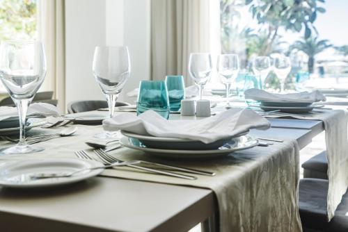 a dining table with glasses and plates and silverware at MH Atlantico in Peniche