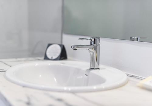 a bathroom sink with a faucet and a mirror at MH Atlantico in Peniche