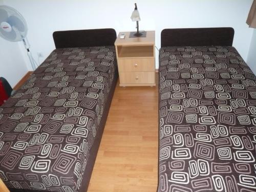 a bedroom with a bed and a nightstand with a bed sidx sidx at Galerius Apartment in Siófok