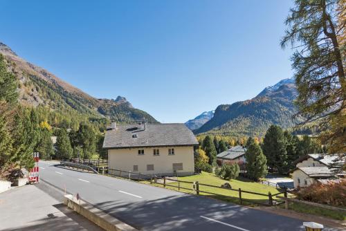 a house on the side of a road next to a mountain at Chesa Muragl - Pontresina in Pontresina