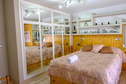 a bedroom with two beds and a large mirror at Mequedo San Pascual in Alcañiz